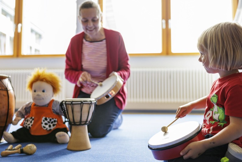 Ein Kind mit einer Trommel im Musikgarten