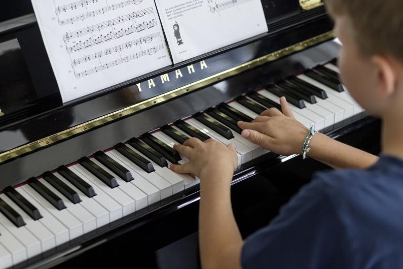 Ein junge spielt auf einem Klavier