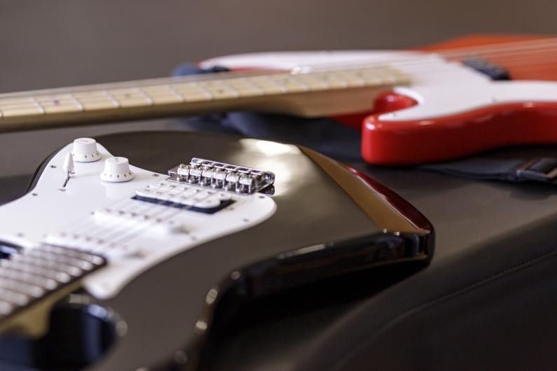 Eine E-Gitarre und ein E-Bass liegen auf einem Tisch