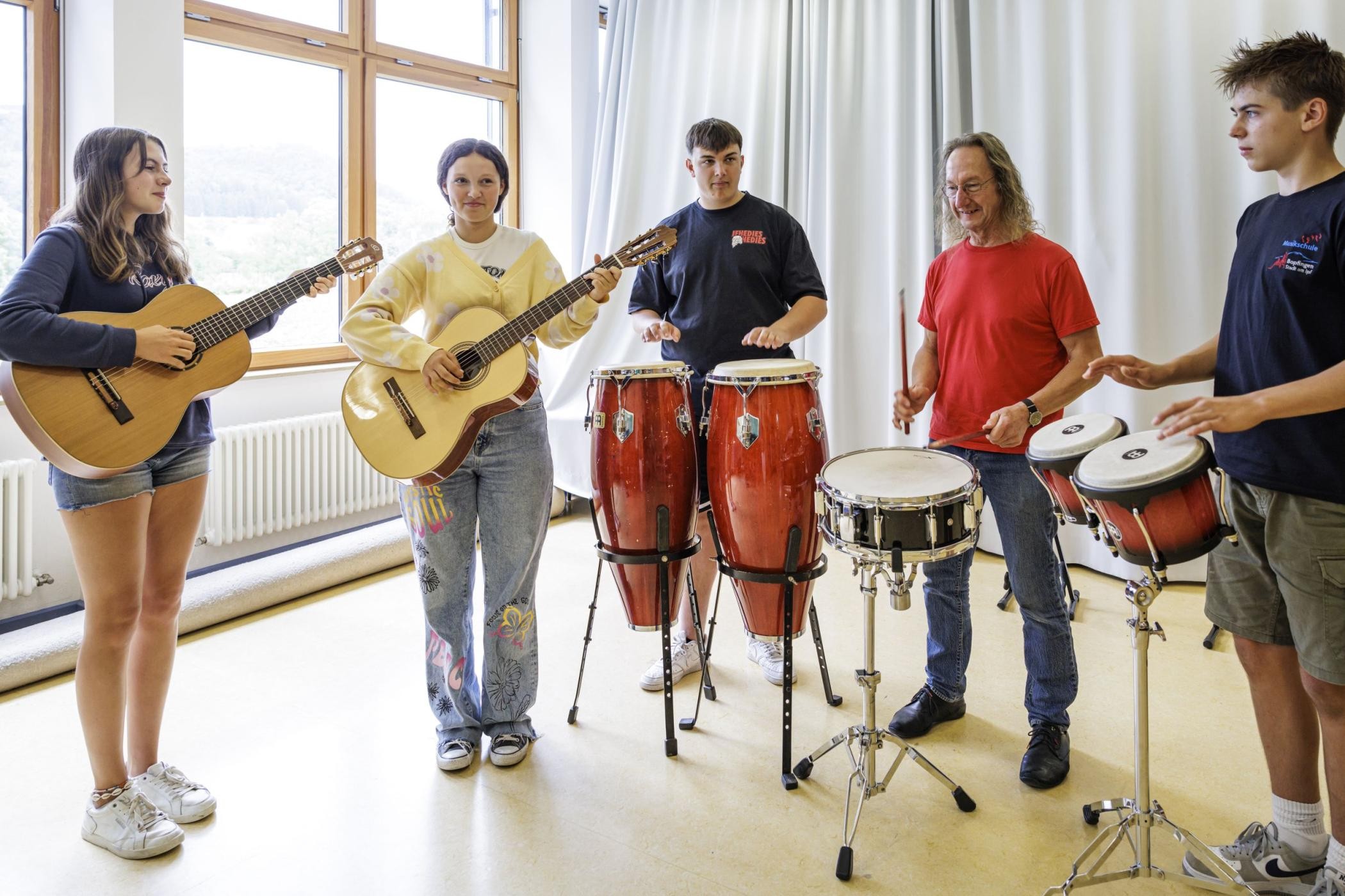 Eine Gruppe von Musizierienden mit einer Lehrkraft in der Musikschule